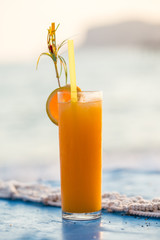 Glass of fresh orange juice over blue tabletop
