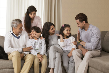 Happy multi-generation family sitting on sofa