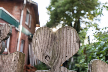Herz aus Holz am Gartenzaun mit Sonne