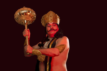 Man dressed as Raavan holding a mace 