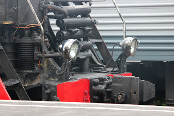 Powerful lights of old locomotive stands on the railroad tracks on the day of the railwayman.