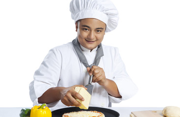 Portrait of chef grating cheese on pizza