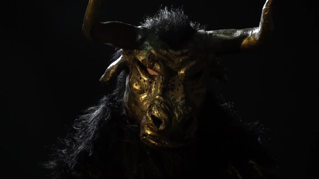 The man in the mask of the minotaur sits in the dark