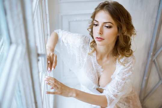 Fashionable female portrait of cute lady in white robe indoors