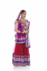 Full length portrait of beautiful Indian bride against white background