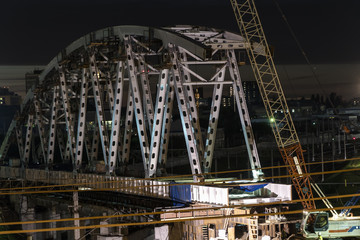 The construction of a steel bridge and night movement of trains on a railway junction