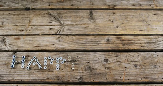 Happy fathers day text with old nails, screws, nuts and bolts arranged on wooden plank 