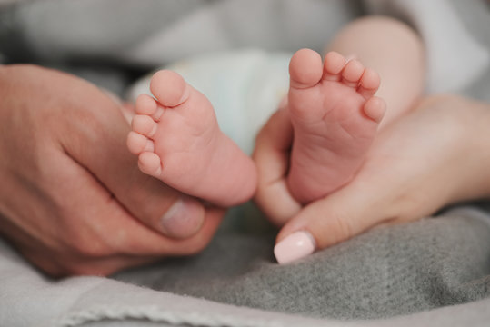 father and mother holding babies feet