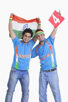 Portrait of happy male cricket fans in jerseys cheering over white background 