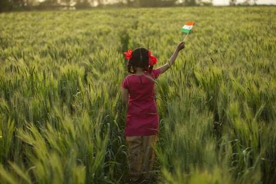 Rear view of little girl holding an Indian flag 