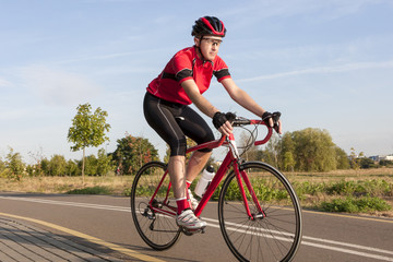 Obraz premium Cycling Concepts and Ideas. Male Caucasian Road Cyclist During Ride on Bike Outdoors. Completely Equipped in Professional Outfit.