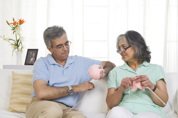 Fototapeta premium Husband helping while his wife is knitting