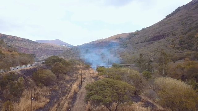 Slow flight over burnt patch near valley road in South Africa