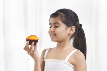 Little girl holding a cupcake