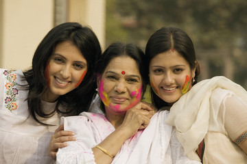 Mother and daughters celebrating Holi 