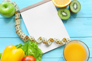 Blank notebook and healthy food on wooden table. Weight loss concept
