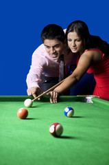 Man teaching woman pool 