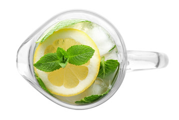 Glass jug of cold lemonade on white background