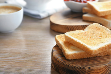 Fototapeta na wymiar Wooden board with tasty breakfast toasts on table