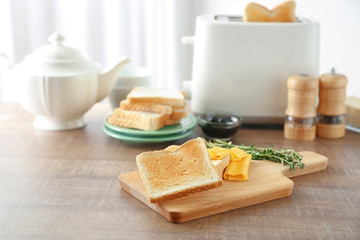 Wooden board with tasty breakfast toasts on table