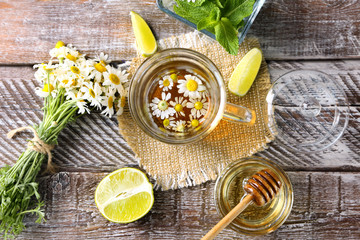 Composition with tasty chamomile tea on wooden background