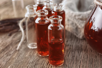 Small bottles with aromatic vanilla extract on table