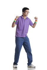 Full length of young man in casual wear looking away with clenched fists over white background 