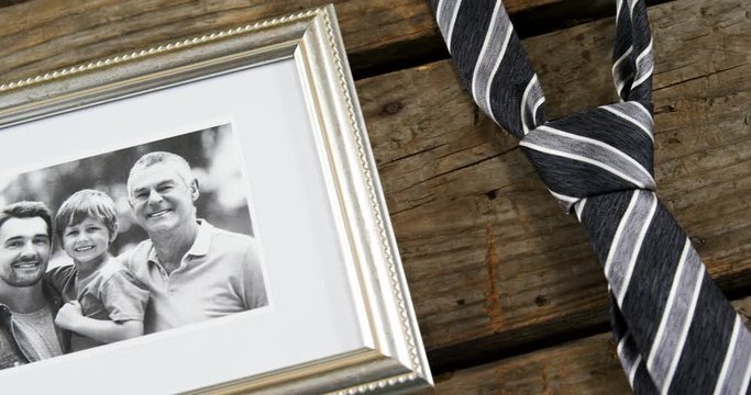 Photo frame and tie on wooden plank