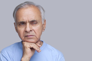 Close-up of senior man with hand on chin 