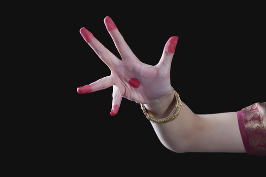 Close-up of a woman's hand making Bharatanatyam gesture called Alapadma on black background