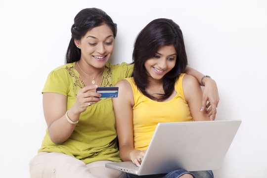Mid adult woman and her daughter shopping online 