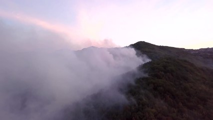 aerial view video 4K, summer fires in Europe forests 2017, 9th of august Montenegro Lovcen, aircraft extinguishes a fire, white smoke clouds, the trees are burning, aero video shooting