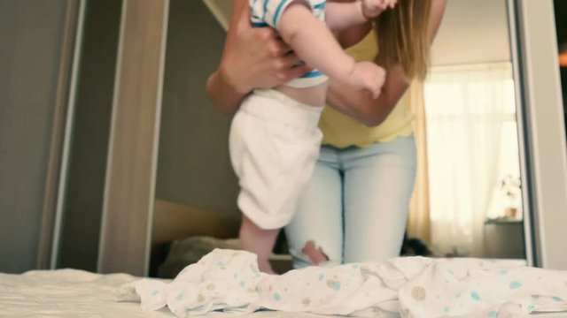 Mother comes to a crying baby to change his diaper