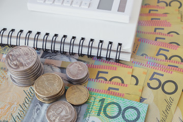 Australian money, AUD with calculator, notebook, donate, charity, household income, Coronavirus economic stimulus rescue package, superannuation concept