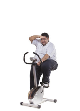 Obese man on exercise bike 