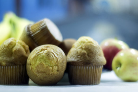 Pan dulce, cubiletes en mesa con otros alimentos desenfocados