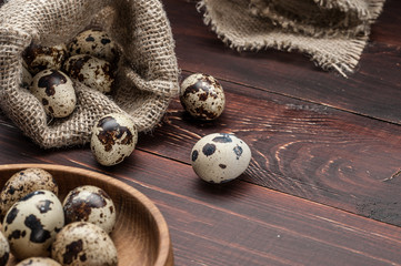 quail eggs in burlap sack over old wooden background