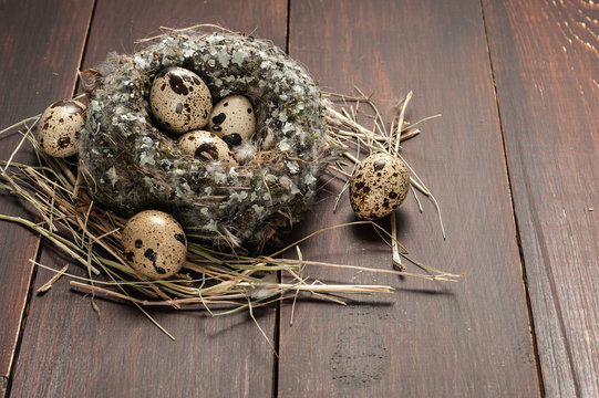 quail eggs in a nest over old wooden background