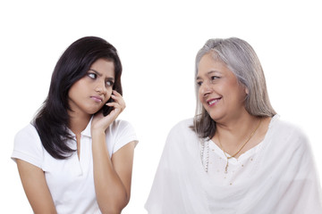 Irritated teenage girl looking at her grandmother 