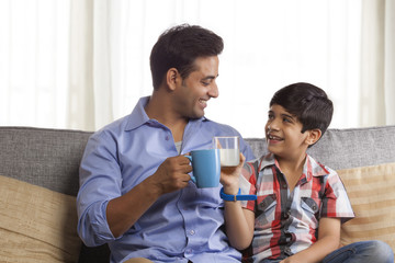 Father and son raising the toast with drinking glasses 