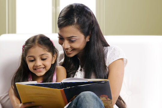Mother and daughter reading a story book 