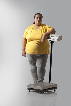 Portrait of obese woman with weighing scale