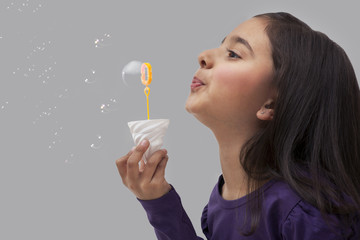 Young girl blowing bubbles 