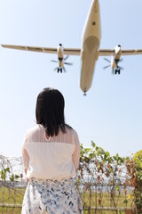 飛行機を眺める女性