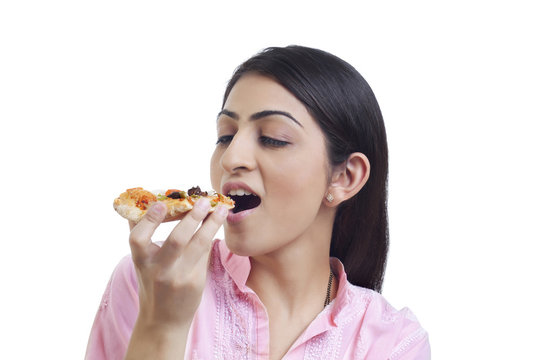 Woman eating slice of pizza 