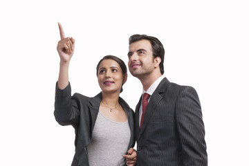 Smiling businesswoman showing something to colleague against white background