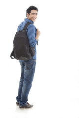 Full length of young man walking with bag against white background 