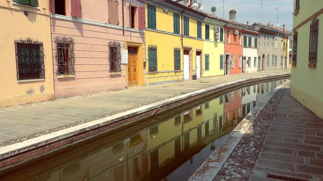 Venetian feelings of water flowing in street channel of an old lagoon town near Ferrara in color graded clip