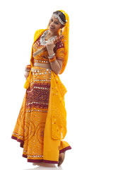 Full length portrait of happy young woman in chaniya choli holding dandiyas over white background