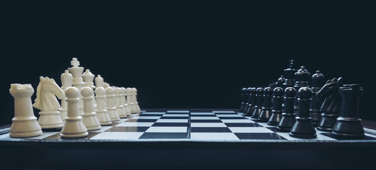 Beginning of the game, Two chess teams in front of different color white and black on the chessboard